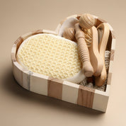 Set of wooden bath tools including a loofah in a decorative wooden holder on a white background