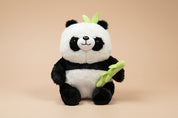 Plush panda toy holding a bamboo stick on a white background