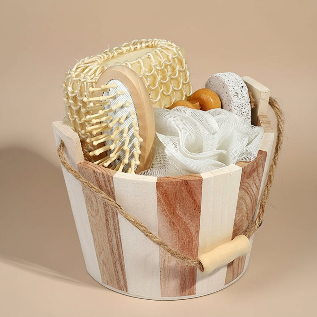 Wooden basket with bath items including a brush, loofah, and washcloth on a marble surface.