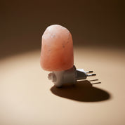 Himalayan salt lamp with white base on a white background