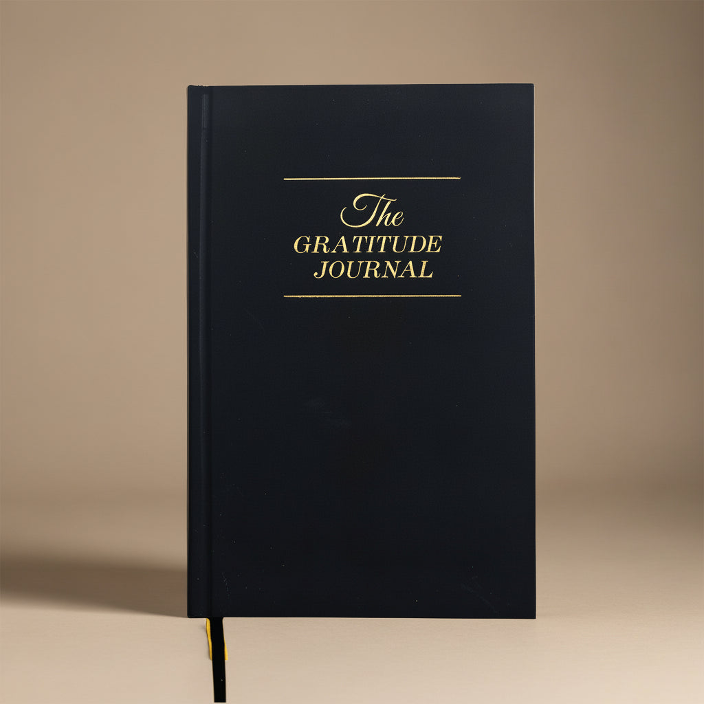 Black gratitude journal with gold text on a white background