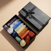 Set of colorful crystals in a black box with a gray ribbon on a light gray background